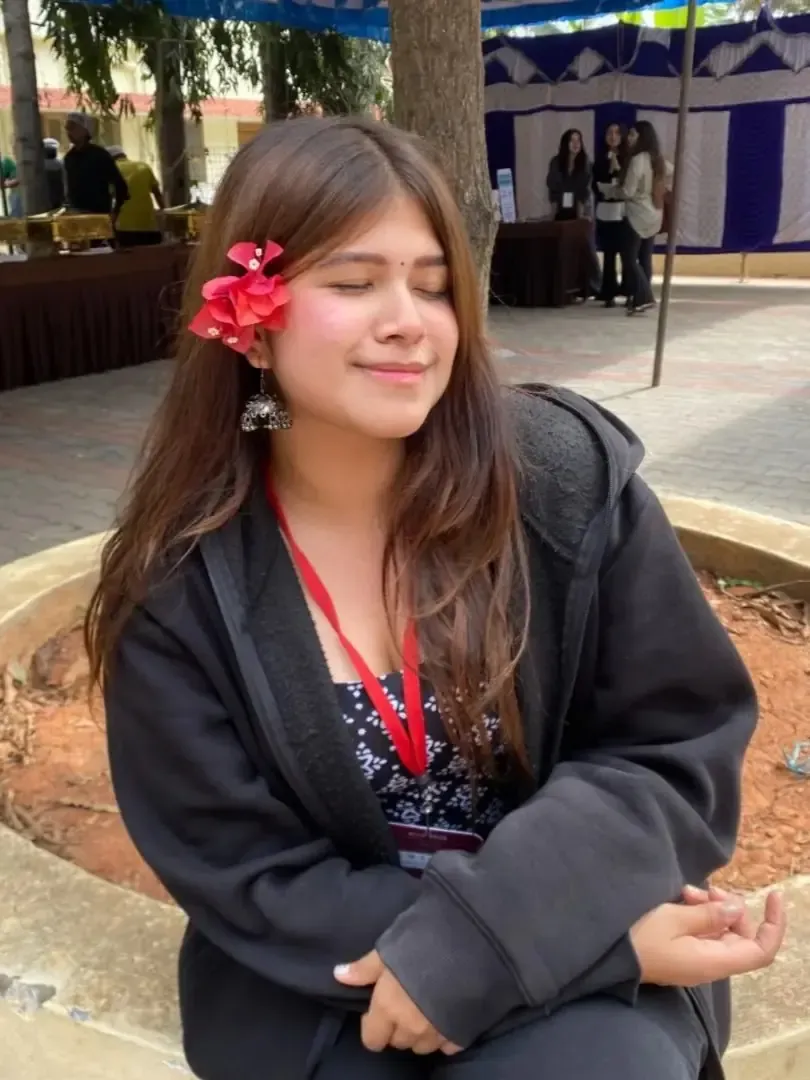 Tamanna Sharma smiling, with a red flower tucked in her hair